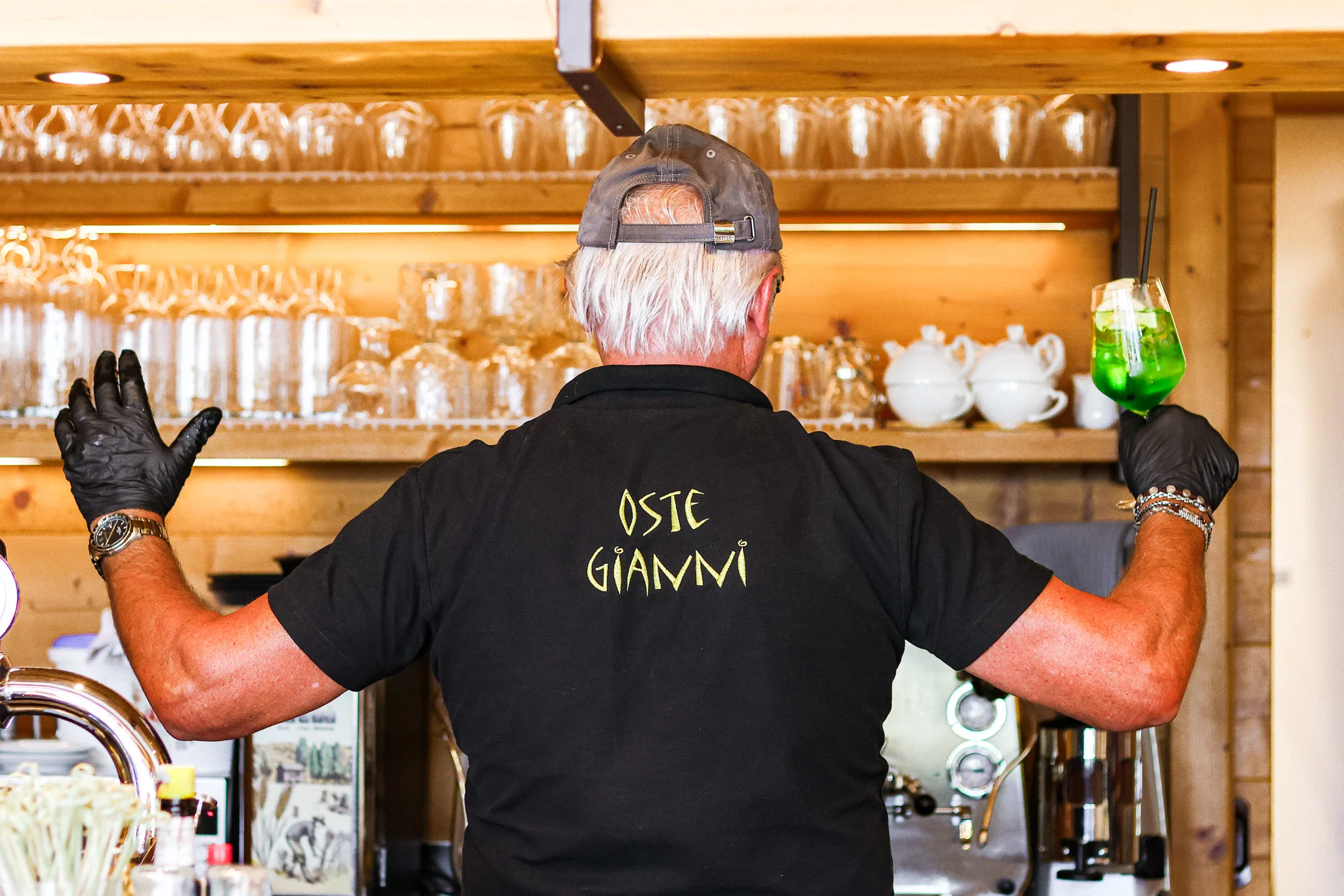 Oste Gianni al bancone con un cocktail alla Locanda La Baita